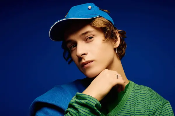 Stylish young man poses thoughtfully, showcasing his unique fashion sense and confidence. — Stock Photo
