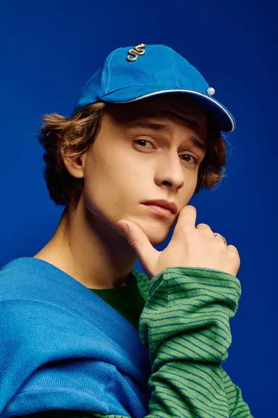 Fashionable young man poses thoughtfully, highlighting youthful style with confident expression. — Stock Photo