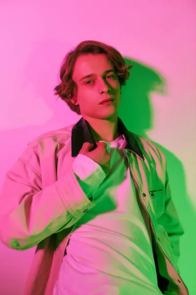 A stylish young man poses confidently against a vibrant backdrop, reflecting youth culture. — Stock Photo