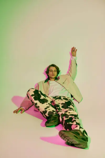 A young man in a trendy outfit lounges on the floor, exuding confidence and style. — Stock Photo