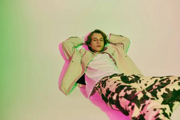 Charming young man poses comfortably, revealing trendy outfit with stylish flair and confidence. — Stock Photo