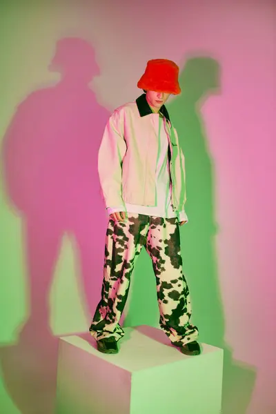 A stylish young man confidently poses in vibrant, artistic attire. — Stock Photo