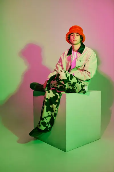 Stylish young man poses confidently on a geometric pedestal, radiating contemporary fashion vibes. — Stock Photo