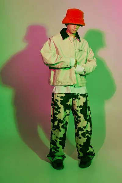 A young man in a trendy bucket hat and stylish outfit exudes youthful confidence. — Stock Photo