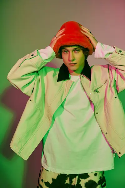 A young man in a trendy outfit poses confidently, surrounded by stylish hues and modern vibes. — Stock Photo