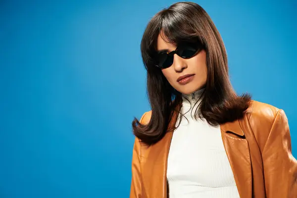 Stylish Asian woman confidently poses in trendy leather jacket and chic sunglasses, exuding youth. — Stock Photo