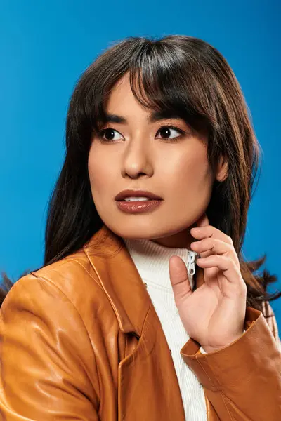 A confident young Asian woman models trendy fashion in a vibrant setting. — Stock Photo