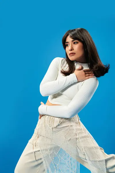 Stylish young woman poses creatively in fashionable attire radiating confidence and modernity. — Stock Photo