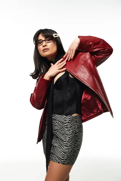A young Asian woman poses confidently in her chic outfit against a neutral backdrop. — Stock Photo