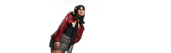 Confident young asian woman showcases her fashionable attire and style against a sleek background. — Stock Photo