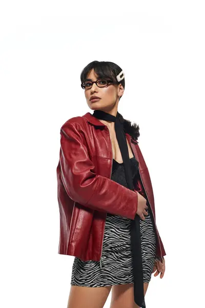 A young Asian woman confidently flaunts her stylish red jacket and trendy accessories. — Stock Photo
