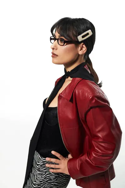 Young Asian woman models a chic outfit against a minimal backdrop, radiating modern flair. — Stock Photo