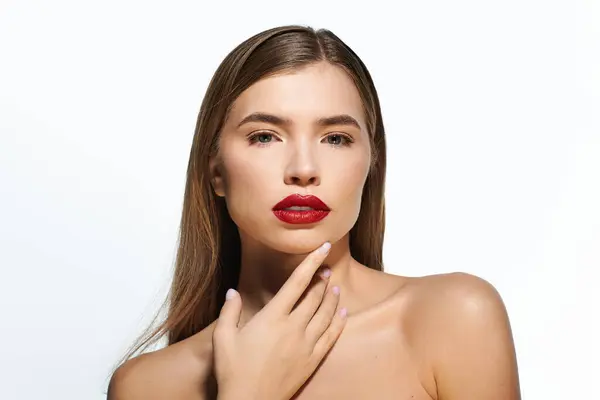 Mujer joven con estilo con el pelo largo y maquillaje llamativo posa con gracia, destacando su belleza. - foto de stock