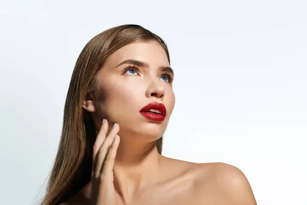 Beautiful young woman with glossy lips poses gracefully, radiating confidence and style. — Stock Photo