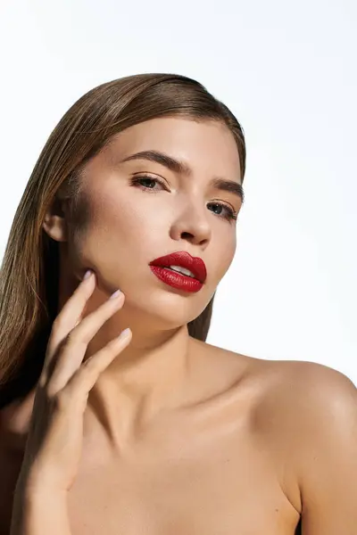 Confident young woman poses gracefully, highlighted by striking lip color against a clean backdrop. — Stock Photo