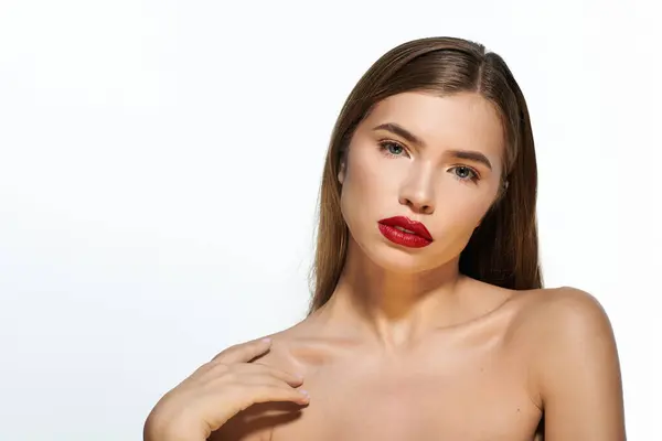 A young woman poses elegantly, showcasing her stylish look and striking red lips. — Stock Photo
