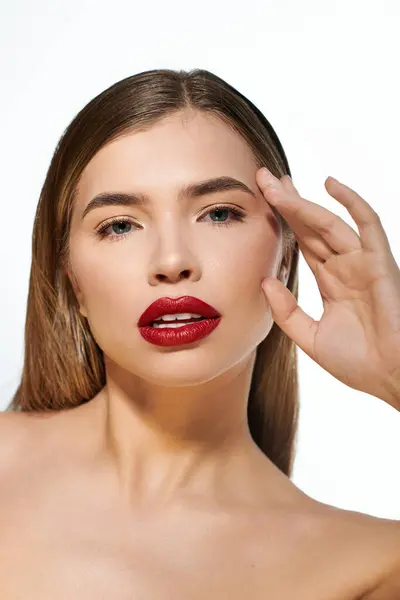 In a captivating setting, a young woman showcases her beauty with bold makeup and a stylish pose. — Stock Photo