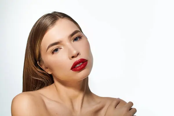A lovely young woman poses gracefully, showcasing vibrant red lips and a captivating gaze. — Stock Photo