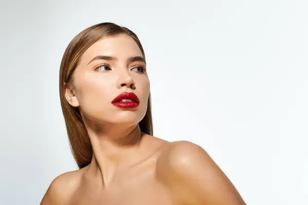 A confident young woman shines in a stylish look with bold red lips against a clean backdrop. — Stock Photo