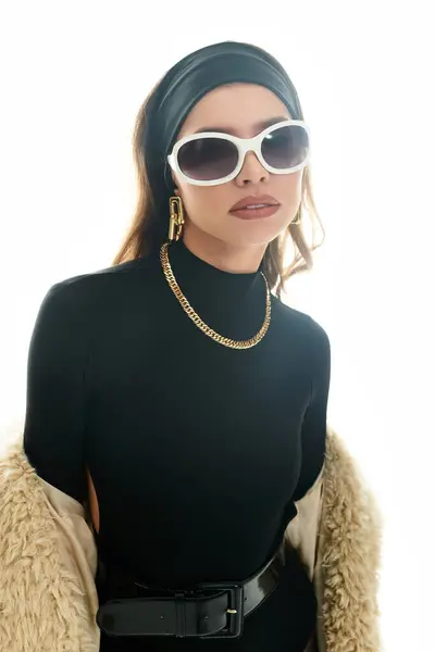 Uma jovem mulher em roupas pretas chiques posa com confiança, ostentando acessórios elegantes. — Fotografia de Stock