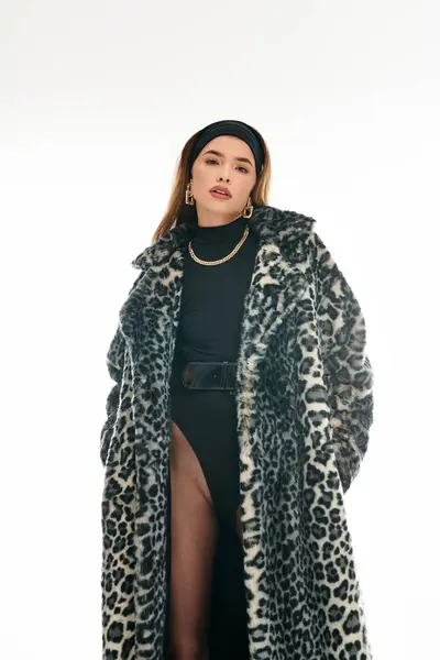 A young woman exudes confidence while wearing stylish attire, standing amidst a trendy backdrop. — Stock Photo