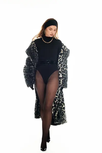 Young woman strides confidently in a chic outfit with a bold animal print coat. — Stock Photo