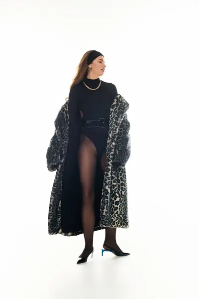 Confident young woman wears a striking leopard coat and chic outfit, radiating elegance and style. — Stock Photo