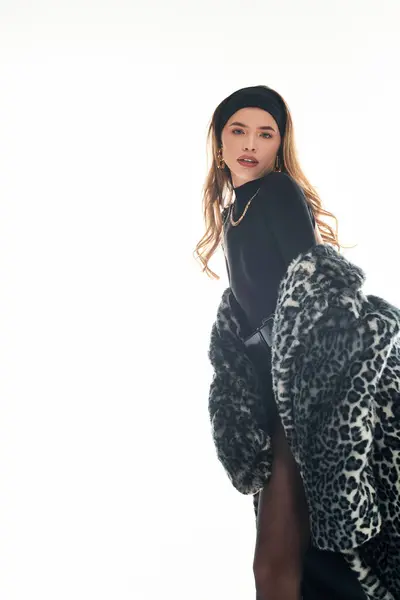 A young woman displays her style with a striking outfit and pose in a minimalist setting. — Stock Photo