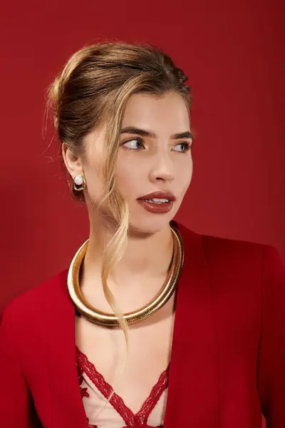 Young woman radiates beauty and confidence, adorned in chic attire against a bold red background. — Stock Photo