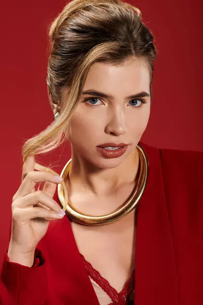 Young woman exudes elegance and charm while wearing a chic red ensemble and statement jewelry. — Stock Photo
