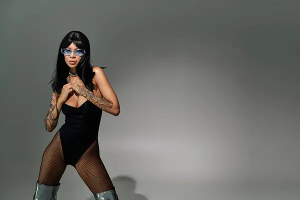 Joven entusiasta de la moda presenta un estilo y actitud llamativos con accesorios audaces y arte corporal - foto de stock