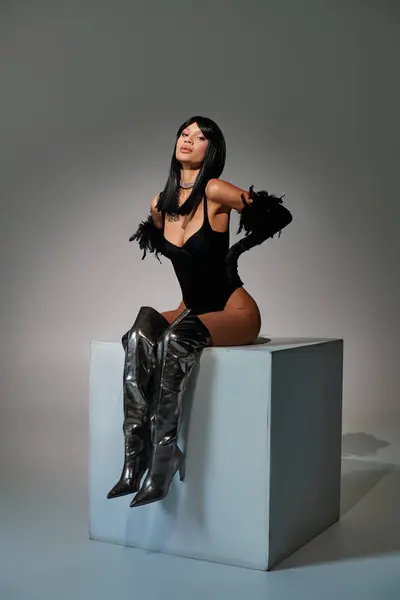 Elegantly poised on a pedestal, the fashionable woman highlights her unique style and allure. — Stock Photo