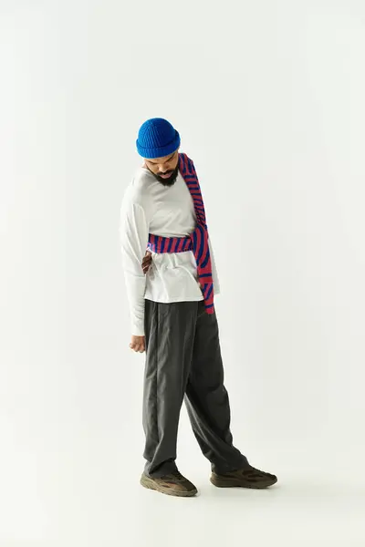 A stylish young man displays his trendy outfit in a calm, charming setting. — Stock Photo