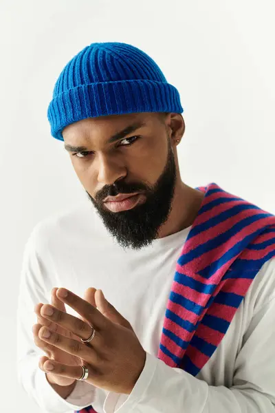 Bel homme avec une barbe met en valeur un look à la mode avec des couleurs frappantes tout en posant avec confiance. — Photo de stock