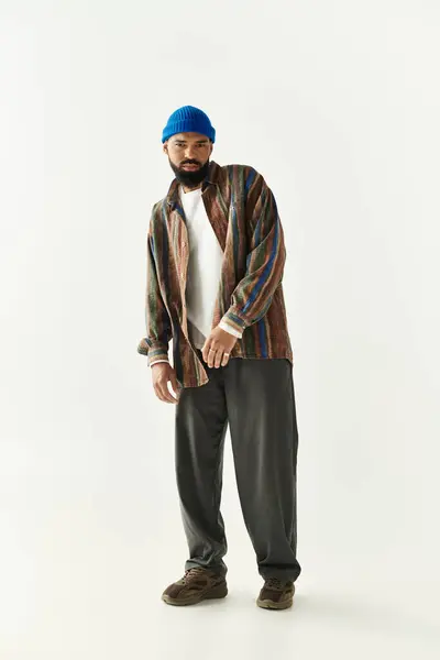Young man showcases a trendy outfit against a bright backdrop, highlighting his style. — Stock Photo