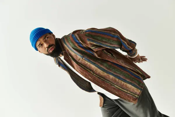 Handsome man in colorful attire poses confidently against a minimalist backdrop, radiating style. — Stock Photo