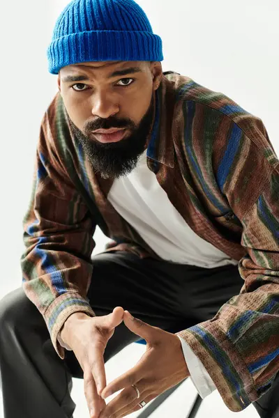 Un jeune homme élégant présente son sens de la mode avec une tenue colorée dans un studio lumineux. — Photo de stock