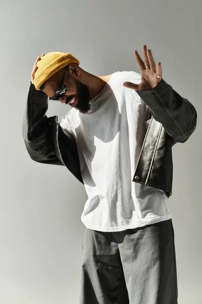 A stylish young man poses confidently in a trendy outfit within a minimalist space. — Stock Photo
