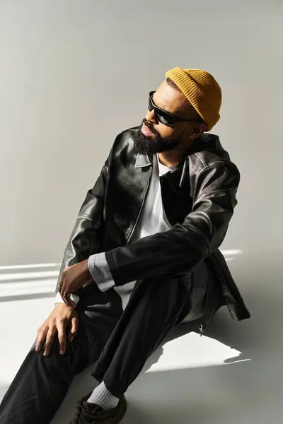 A handsome young man displays his fashion sense in a moment of relaxed sophistication indoors. — Stock Photo