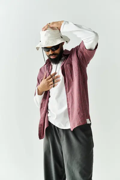Confident man in trendy attire blends style and charisma against a clean backdrop. — Stock Photo