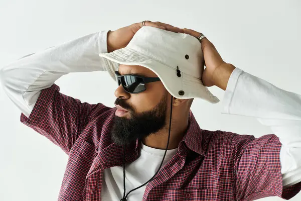 Bello uomo vestito in abiti alla moda posa con un atteggiamento rilassato in un ambiente di studio. — Foto stock