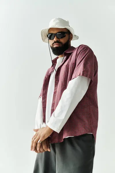 Handsome young man strikes a fashionable pose in a contemporary studio, wearing trendy attire. — Stock Photo