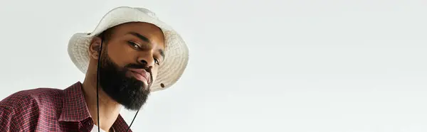 Jeune homme porte une tenue et un chapeau à la mode, exprimant son style et sa personnalité uniques. — Photo de stock