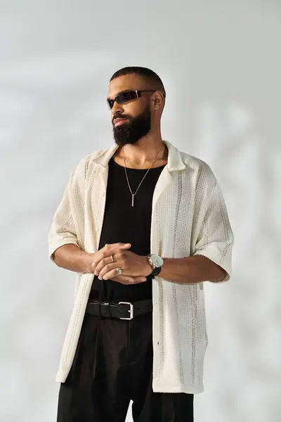 Confident young man dressed in trendy attire stands poised, showcasing modern fashion choices. — Stock Photo