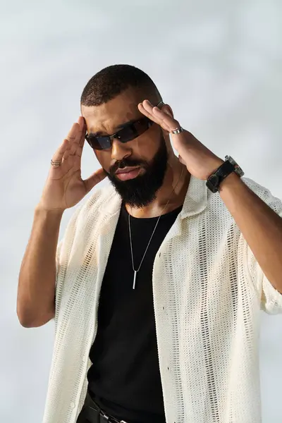 Young man exhibits effortless style while striking a confident pose against a light backdrop. — Stock Photo