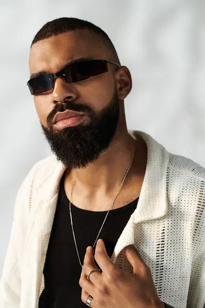 Handsome man showcases his unique style with sunglasses and a trendy outfit in bright lighting. — Stock Photo