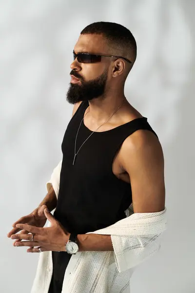 A fashionable young man stands confidently, showcasing his modern style and charisma. — Stock Photo