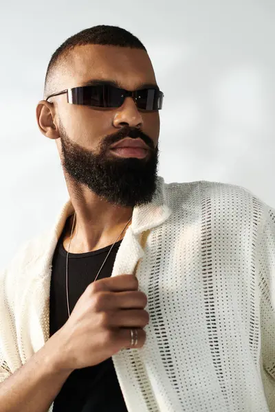 A stylish man with a groomed beard confidently showcases his fashion outdoors. — Stock Photo