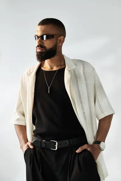 Schöner Mann versprüht Charme, wenn er in einem schicken Outfit vor einem weichen Hintergrund steht und groß ist. — Stockfoto