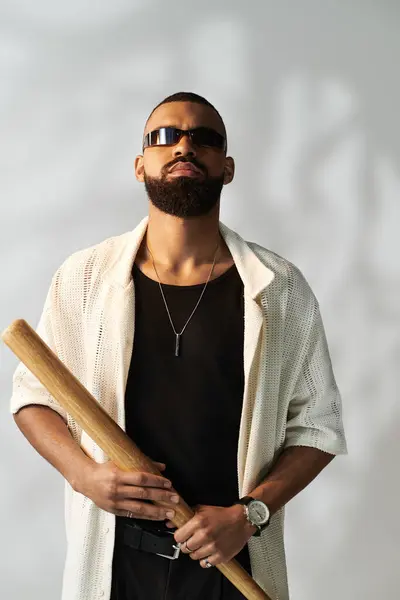 A young man exudes charm and coolness while stylishly holding a baseball bat. — Stock Photo